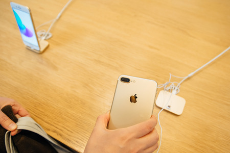 PARIS, FRANCE - SEPTEMBER 16, 2016: New Apple iPhone 7 Plus being tested by woman after purchase - looking at the new double iSight camera. New Apple iPhone tends to become one of the most popular smart phones in the world in 2016のeditorial素材