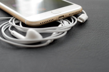 PARIS, FRANCE - SEP 16 2016: New Apple iPhone 7 Plus unboxing in the first day of sales - Lighting audio conector and earpods. New Apple iPhone acclaims to become the most popular smart phone in the world in 2016のeditorial素材