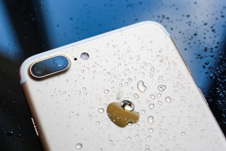 PARIS, FRANCE - SEP 26, 2016: New Apple iPhone 7 Plus unboxing and testing - rain drops on back of the phone. New iPhone7 is one of the best waterproof smart phone in the worldのeditorial素材