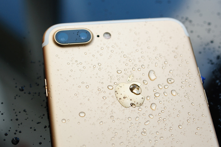 PARIS, FRANCE - SEP 26, 2016: New Apple iPhone 7 Plus unboxing and testing - rain drops on back of the phone. New iPhone7 is one of the best waterproof smart phone in the worldのeditorial素材