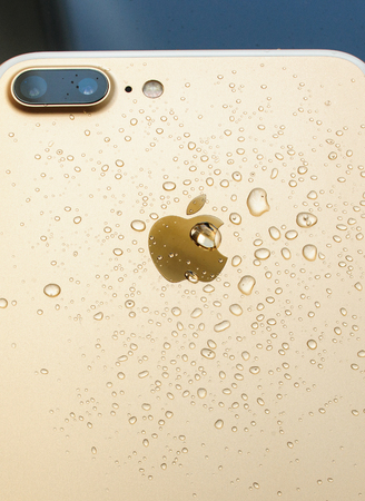 PARIS, FRANCE - SEP 26, 2016: New Apple iPhone 7 Plus unboxing and testing - rose gold model with double camera and water drops. New iPhone7 is one of the best waterproof smart phone in the worldのeditorial素材