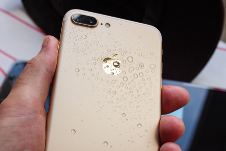 PARIS, FRANCE - SEP 26, 2016: New Apple iPhone 7 Plus unboxing and testing - hand holding wet iPhone. New iPhone7 is one of the best waterproof smart phone in the worldのeditorial素材