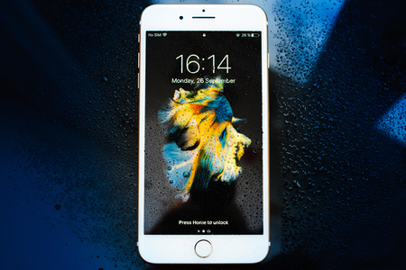 PARIS, FRANCE - SEP 26, 2016: New Apple iPhone 7 Plus unboxing and testing - locked iPhone covered with water drops. New iPhone7 is one of the best waterproof smart phone in the worldのeditorial素材