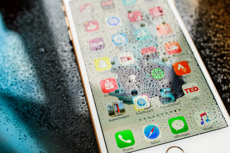 PARIS, FRANCE - SEP 26, 2016: New Apple iPhone 7 Plus unboxing and testing - home screen with apps under rain  . New iPhone7 is one of the best waterproof smart phone in the worldのeditorial素材