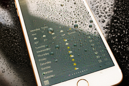 PARIS, FRANCE - SEP 26, 2016: New Apple iPhone 7 Plus unboxing and testing - weather app on iPhone screen with forecast. New iPhone7 is one of the best waterproof smart phone in the worldのeditorial素材