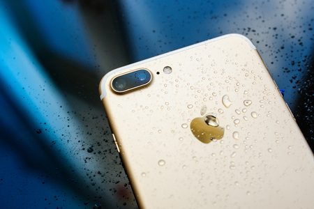 PARIS, FRANCE - SEP 26, 2016: New Apple iPhone 7 Plus unboxing and testing - rain drops on back of the phone. New iPhone7 is one of the best waterproof smart phone in the worldのeditorial素材