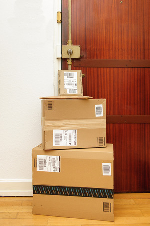 PARIS, FRANCE - SEP 4, 2016: Multiple Amazon boxes left at the door with logotype printed on cardboard box.  Amazon is an American electronic e-commerce company distribution worlwide e-commerce goodsのeditorial素材