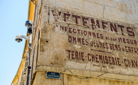 AIX-EN-PROVENCE, FRANCE - JUL 17, 2014: Old inscription on building of a store selling clothes with the street name Rue Lieutad and two security camera surveilling the cityのeditorial素材