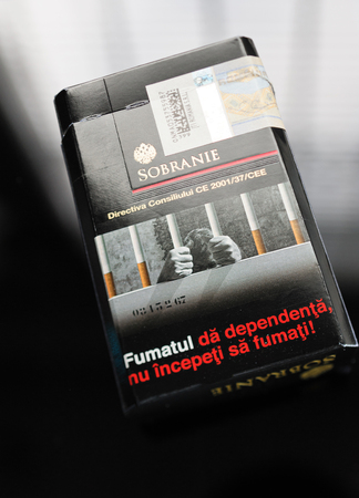 FRANKFURT, GERMANY - SEP 22, 2016: Sobranie cigarettes pack on glass table with inscription Quit Smoking Now in Romanian langauge. The Sobranie cigarette brand is one of the oldest luxury tobacco brands in the world. Sobranie of London was established in のeditorial素材
