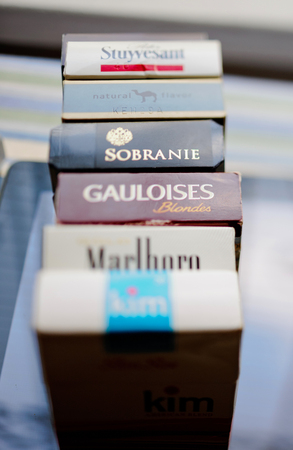 FRANKFURT, GERMANY - SEP 22, 2016: Multiple cigarettes pack on glass table arranged in a row and photographed with a tilt-shift lensのeditorial素材