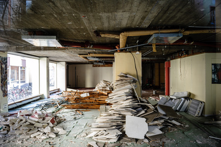 Horizontal view of abandoned interior of a business store market with lots of damaged lamps, wallsの写真素材