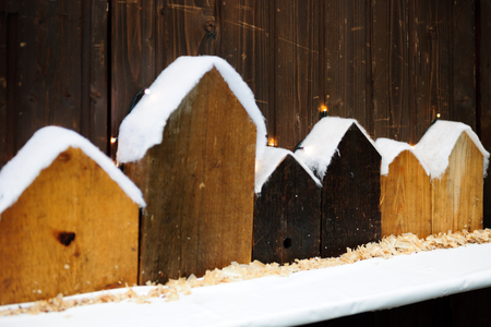 Traditional Christmas wooden houses for birds and as decorations covered with artifical snowの写真素材