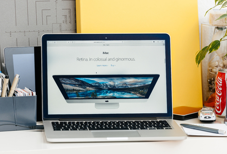 PARIS, FRANCE - OCT 28 2016: Apple Computers website on new MacBook Pro Retina with OLED touch bar in a geek creative room showcasing the iMac retina display in colossal and ginormousのeditorial素材