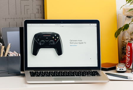PARIS, FRANCE - OCT 28 2016: Apple Computers website on new MacBook Pro Retina with OLED touch bar in a geek creative room showcasing new professional laptop - Get more from your Apple TV joystick for playing gamesのeditorial素材
