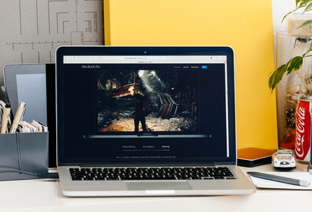PARIS, FRANCE - OCT 28 2016: Apple Computers website on new MacBook Pro Retina with OLED touch bar in a geek creative room showcasing new professional laptop - detail of game runnning on the new laptopのeditorial素材