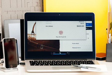 PARIS, FRANCE - OCT 28 2016: Apple Computers website on new MacBook Pro Retina with OLED Touch bar in geek creative room showcasing Apple Keynote presentation of Pay with TTouch ID OLEd barのeditorial素材