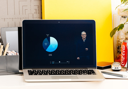 PARIS, FRANCE - OCT 28 2016: Apple Computers website on new MacBook Pro Retina with OLED Touch bar in geek creative room showcasing Apple Keynote presentation of iOS vs Android adoption usersのeditorial素材