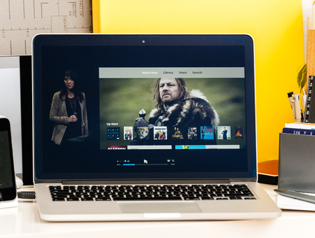 PARIS, FRANCE - OCT 28 2016: Apple Computers website on new MacBook Pro Retina with OLED Touch bar in geek creative room showcasing Apple Keynote presentation of Apple tv Watch now TV app channels movies and showsのeditorial素材
