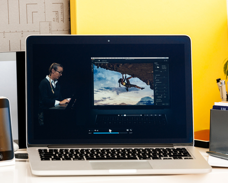 PARIS, FRANCE - OCT 28 2016: Apple Computers website on new MacBook Pro Retina with OLED Touch bar in geek creative room showcasing Apple Keynote presentation of Bradee Evans from Adobe OLED Photoshop inegrationのeditorial素材