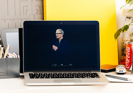 PARIS, FRANCE - OCT 28 2016: Apple Computers website on new MacBook Pro Retina with OLED Touch bar in geek creative room showcasing Apple Keynote presentation of Tim Cook saluting audienceのeditorial素材