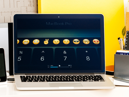 PARIS, FRANCE - OCT 28 2016: Apple Computers website on new MacBook Pro Retina with OLED Touch bar in geek creative room showcasing Apple Keynote presentation of touchbar with Emoji, App integration and shortcutsのeditorial素材