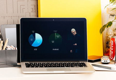 PARIS, FRANCE - OCT 28 2016: Apple Computers website on new MacBook Pro Retina with OLED Touch bar in geek creative room showcasing Apple Keynote presentation of iOS vs Android adoption usersのeditorial素材