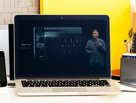 PARIS, FRANCE - OCT 28 2016: Apple Computers website on new MacBook Pro Retina with OLED Touch bar in geek creative room showcasing Apple Keynote presentation of Apple T1 Chip - secure cryptographic engine for Touch IDのeditorial素材
