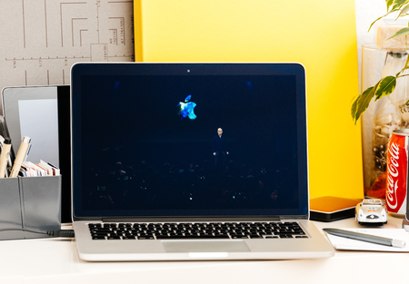 PARIS, FRANCE - OCT 28 2016: Apple Computers website on new MacBook Pro Retina with OLED Touch bar in geek creative room showcasing Apple Keynote presentation of Tim Cook saluting audienceのeditorial素材