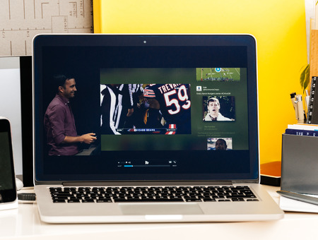 PARIS, FRANCE - OCT 28 2016: Apple Computers website on new MacBook Pro Retina with OLED Touch bar in geek creative room showcasing Apple Keynote presentation of Tv app by Apple Nfl gameのeditorial素材