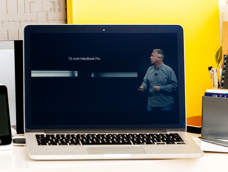 PARIS, FRANCE - OCT 28 2016: Apple Computers website on new MacBook Pro Retina with OLED Touch bar in geek creative room showcasing Apple Keynote presentation of  Philip Schiller talking about the changes of the new laptopのeditorial素材