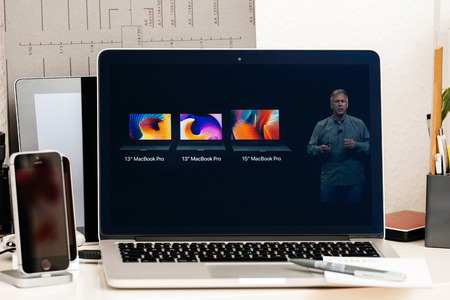 PARIS, FRANCE - OCT 28 2016: Apple Computers website on new MacBook Pro Retina with OLED Touch bar in geek creative room showcasing Apple Keynote Comparing, Shipping, Price, Specs of laptopsのeditorial素材