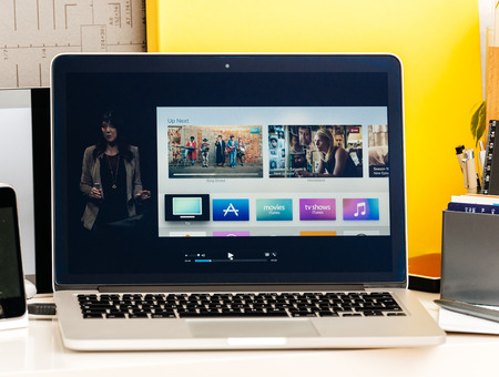 PARIS, FRANCE - OCT 28 2016: Apple Computers website on new MacBook Pro Retina with OLED Touch bar in geek creative room showcasing Apple Keynote presentation of Apple tv Watch now TV app channels movies and showsのeditorial素材