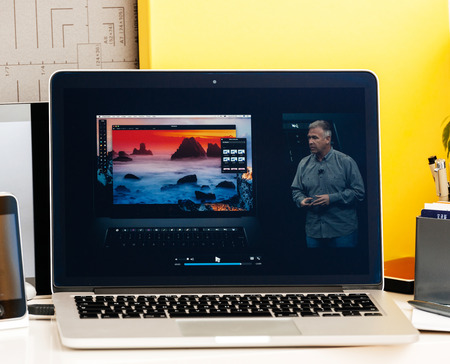 PARIS, FRANCE - OCT 28 2016: Apple Computers website on new MacBook Pro Retina with OLED Touch bar in geek creative room showcasing Apple Keynote presentation of Philip Schiller inegration softwareのeditorial素材