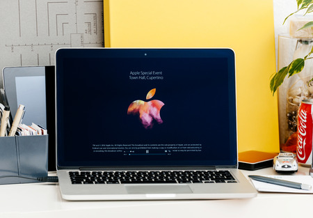 PARIS, FRANCE - OCT 28 2016: Apple Computers website on new MacBook Pro Retina with OLED Touch bar in geek creative room showcasing Apple Keynote presentation of Apple Logo on black screenのeditorial素材