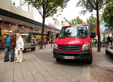 KEHL, GERMANY - OCT 18, 2016: red Mercedes-Benz delivery van in front of Woolworth retail store in typical German street with senior couple walking on a promenadeのeditorial素材