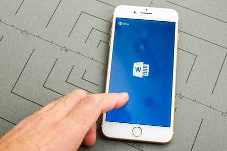 PARIS, FRANCE - SEPT 26, 2016: New iPhone 7 Plus with hand touching screen to make a new Microsoft Word document on mobile phone. iPhone 7 and iPhone 7 plus is the most wanted phone worldwideのeditorial素材