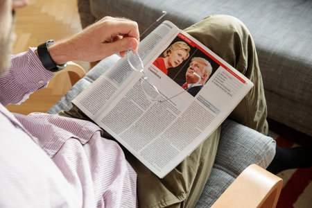 PARIS, FRANCE - NOV 10, 2016: Man reading The Economist magazine with Donald Trump aand Hillary...