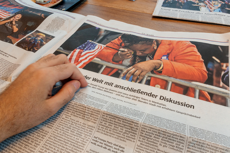 PARIS, FRANCE - NOV 10, 2016: Woman crying after Trump wins - Man reading Frankfurter Allgemeine Zeitung newspapper with Donald Trump elected as President as the 45th President of United States of Americaのeditorial素材