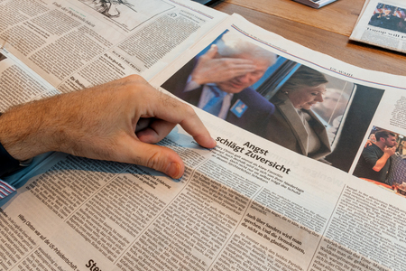 PARIS, FRANCE - NOV 10, 2016: Pointing to Hillary and Bill Clinton -  Man reading Frankfurter Allgemeine Zeitung newspapper with Donald Trump elected as President as the 45th President of United States of Americaのeditorial素材