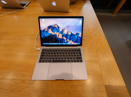 PARIS, FRANCE - NOV 10 2016: New latest MacBook Pro Retina with on wooden table. The fourth generation MacBook Pro was revealed on October 27, 2016. Phil Schiller described it as the "Thinnest and lightest MacBook Pro ever"のeditorial素材