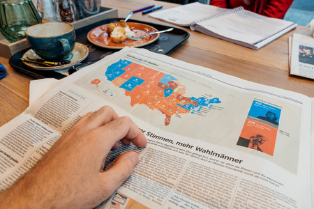 PARIS, FRANCE - NOV 10, 2016: US map election results - Man reading Frankfurter Allgemeine Zeitung newspapper with Donald Trump elected as President as the 45th President of United States of Americaのeditorial素材