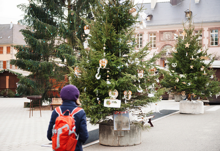 One oman walking in the village of Thann empty Christmas market early in the morning. Thann is a pictoresque village in Alsace, Franceの写真素材