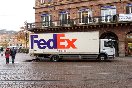 STRASBOURG, FRANCE - 8 NOV 2016: New FEDEX white truck unloading merchandise in beautiful city environment. FedEx is one of the leading parcel services worldwide with main competitors as DHL and UPSのeditorial素材