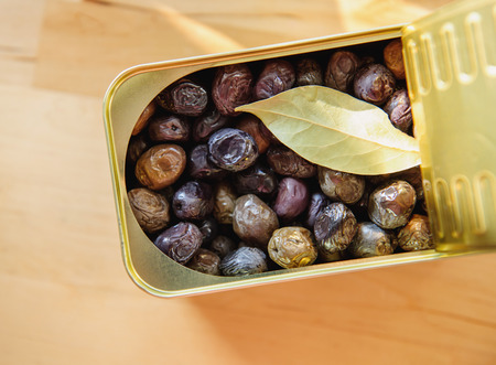 Organic canned olives with bay leave on wooden table seen from aboveの写真素材