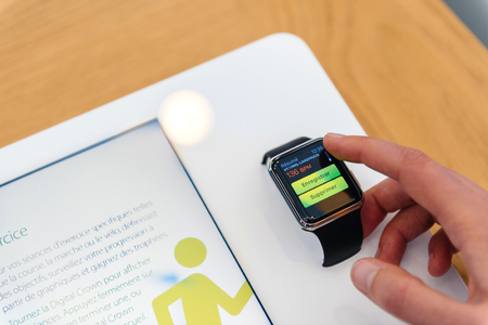 PARIS, FRANCE - SEP 12, 2016: Woman testing new Apple watch testing its functionalities before buying the latest smartwatch - admiring the new heart rate function halthcareのeditorial素材