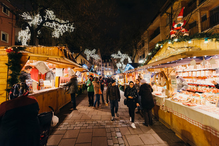 STRASBOURG, FRANCE - DEC 6, 2015: Adults, childrens, grandparents and happy people walking during Christmas Market admiring market stall, buying food, presents and toysのeditorial素材