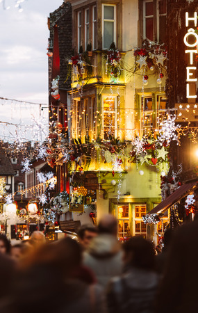 Colorful Christmas Market atmosphere with people silhouettes walking on illuminated street with Christmas toys and decorations in oldest Christmas Market worldwide, Strasbourgのeditorial素材