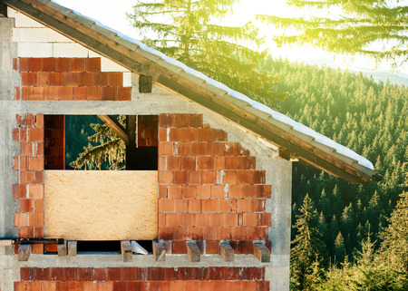 Unfinished vacancy house in the mountains surrounded by beautiful green nature on a sunny dayの写真素材