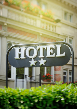 Detail of a luxury Two stars hotel with beautiful building in the background on a beautiful sunny day. Tilt shift lens used to accent the word "hotel" and to emphasize the backgroundのeditorial素材