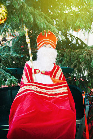 LAHR, GERMANY - 30 NOV, 2013: Saint Nicholas human scale toy with mitre and pastoral staff with a fir Christmas tree on backgroundのeditorial素材